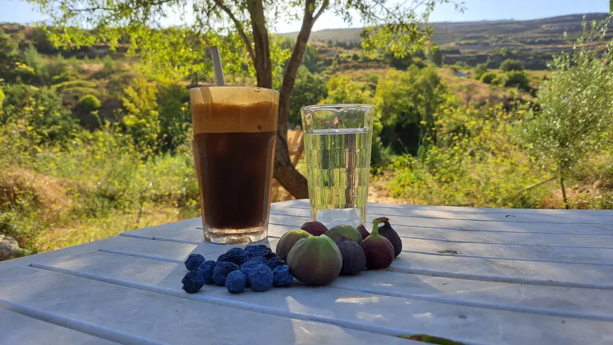 Iced coffee, a glass of water, and some fruits